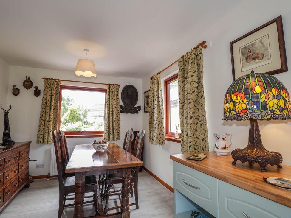 A dining room with a wooden table and chairs at Park House Cannich Holiday Retreat Cannich