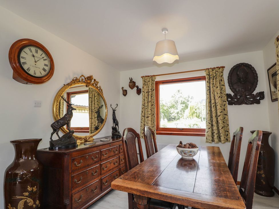 A dining room with a wooden table and chairs at Park House Cannich Holiday Retreat in Cannich
