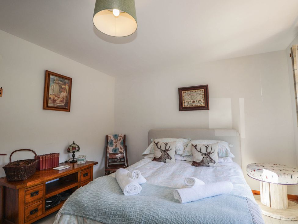 A bedroom with a bed and bedside table at Park House Cannich Holiday Retreat in Cannich