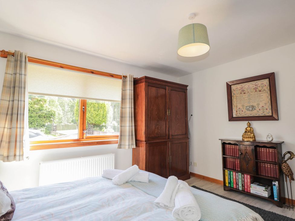 A bedroom with a bed and wardrobe at Park House Cannich Holiday Retreat in Cannich