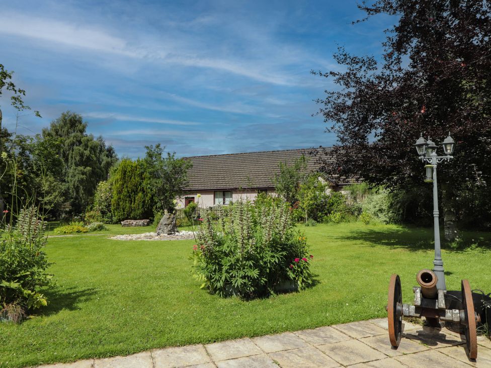 A garden with a cannon and lamp post at Park House Cannich Holiday Retreat in Cannich
