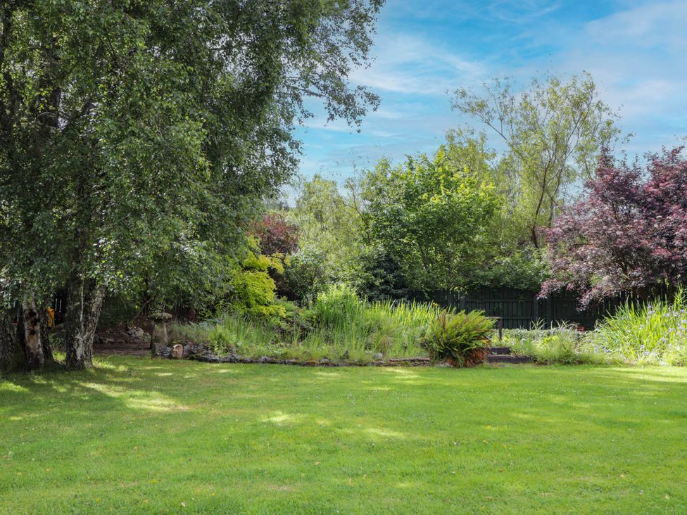 A garden with trees and grass at Park House Cannich Holiday Retreat in Cannich