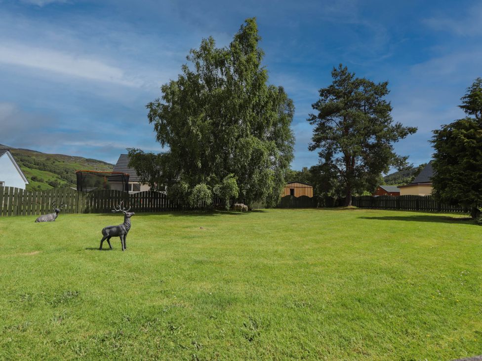 A garden with decorative deer and trees at Park House Cannich Holiday Retreat Cannich