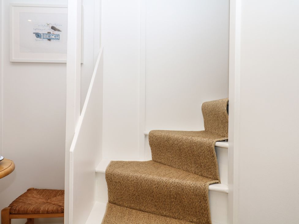 A staircase leading up with carpet and a picture frame at Tower View Cottage Lympstone