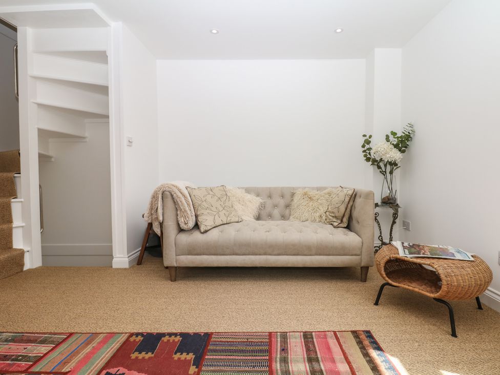 A snug with a sofa and a staircase at Tower View Cottage in Lympstone
