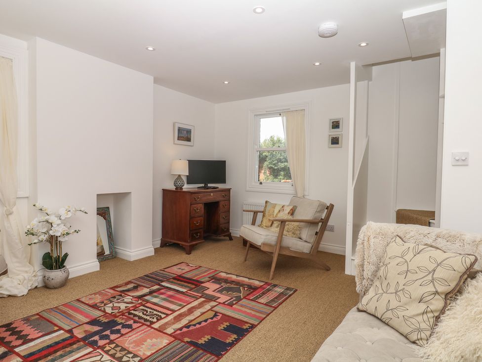 A living room with a desk and television at Tower View Cottage in Lympstone