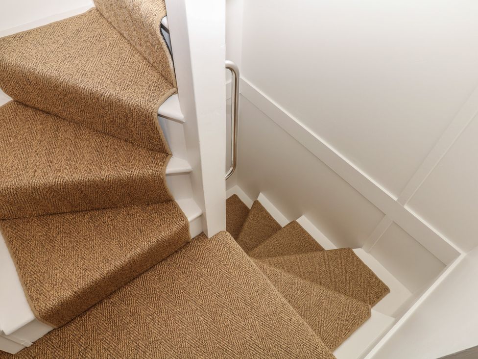 A staircase with carpeted steps and a handrail at Tower View Cottage in Lympstone