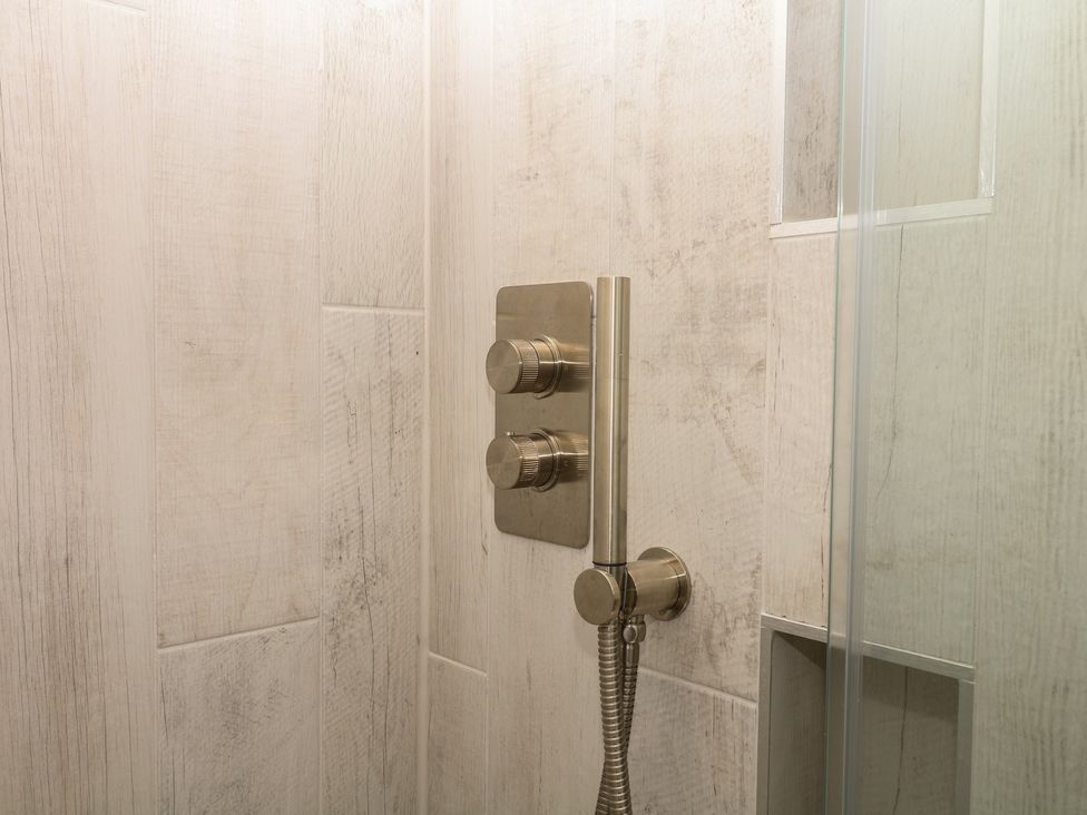 A shower with controls and a handheld showerhead at Tower View Cottage in Lympstone