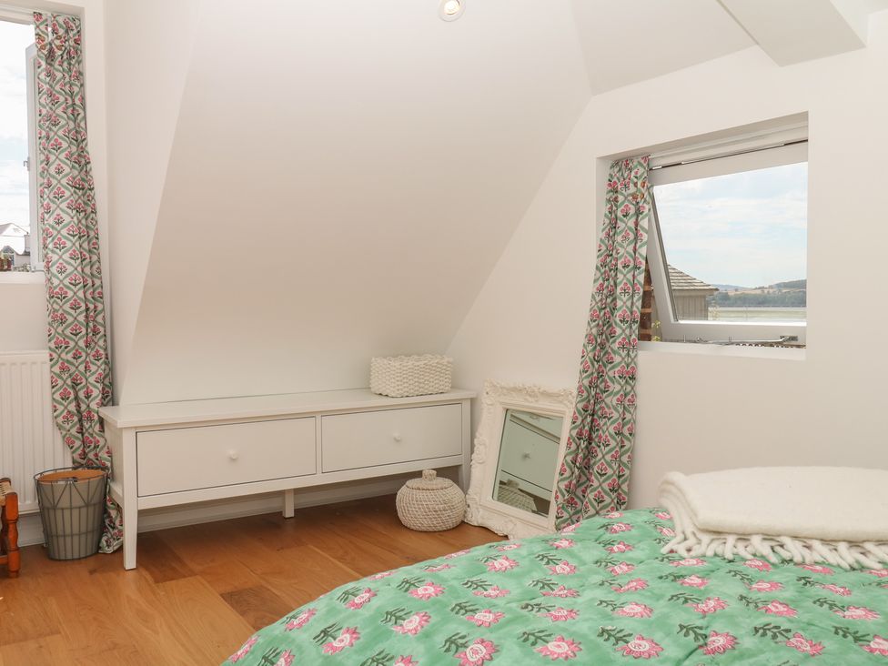 A bedroom with a bed, drawer unit, and window at Tower View Cottage in Lympstone