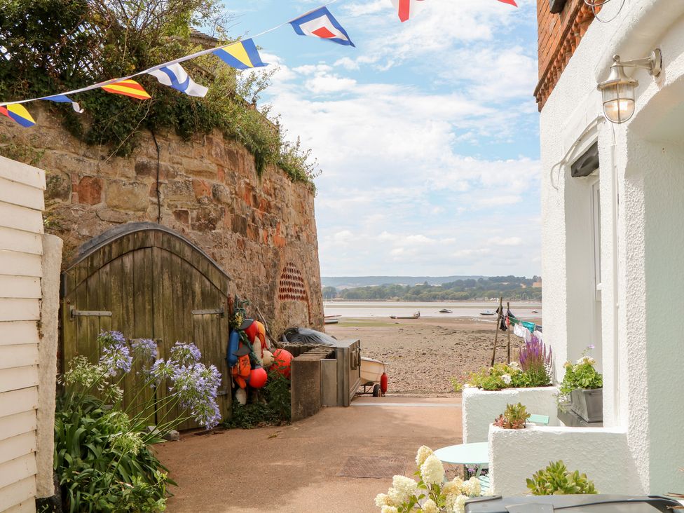 An outdoor area with a stone wall and fishing gear at Tower View Cottage in Lympstone