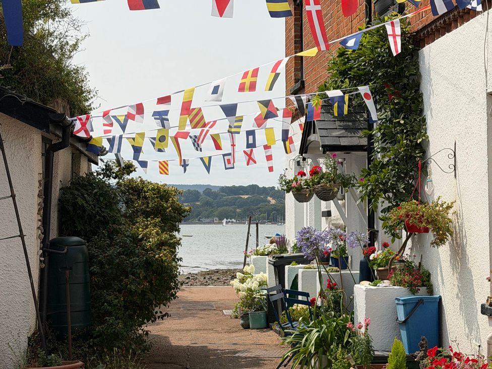 An outdoor pathway decorated with flags and flowers at Tower View Cottage in Lympstone