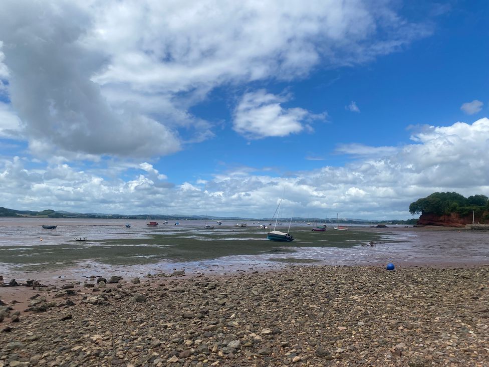 A view of boats on water with rocks and clouds at Tower View Cottage in Lympstone