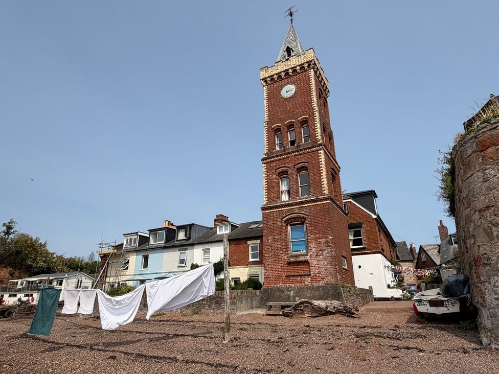 A tower and buildings with laundry on a clothesline at Tower View Cottage in Lympstone