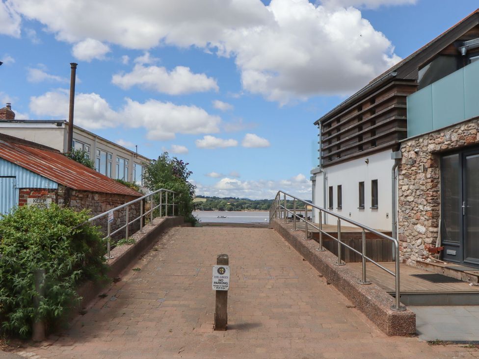 A pathway leading towards water with buildings around at Tower View Cottage in Lympstone