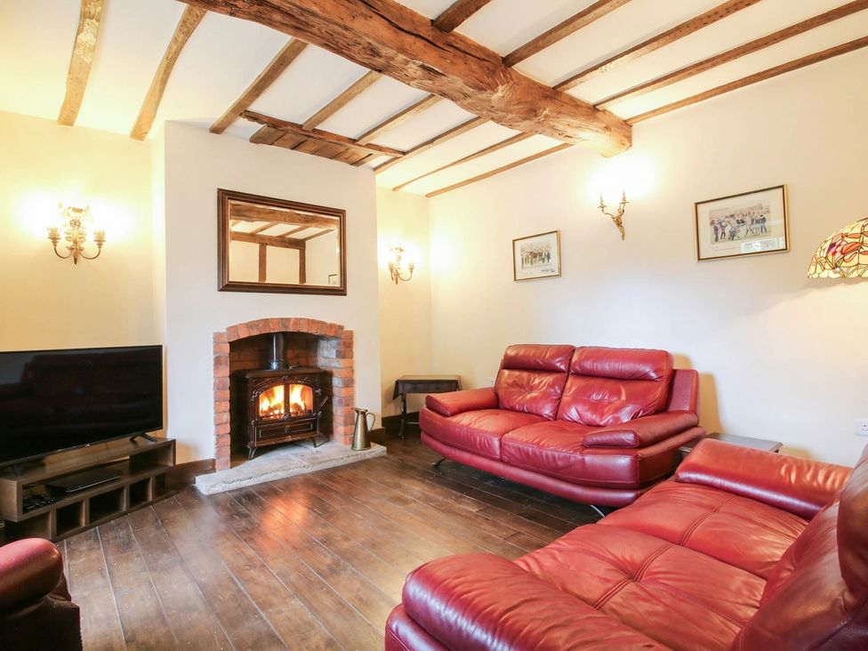 A living room with a fireplace and television at Stone House Farm in Cobnash near Leominster