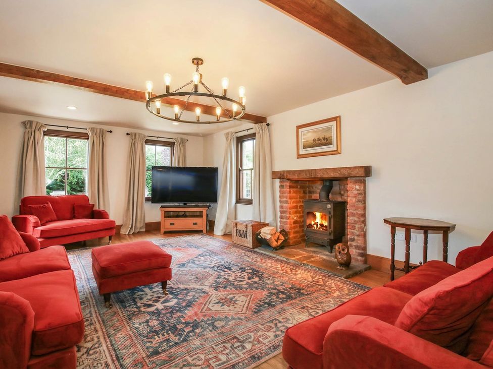 A living room with a fireplace and television at Stone House Farm in Cobnash near Leominster