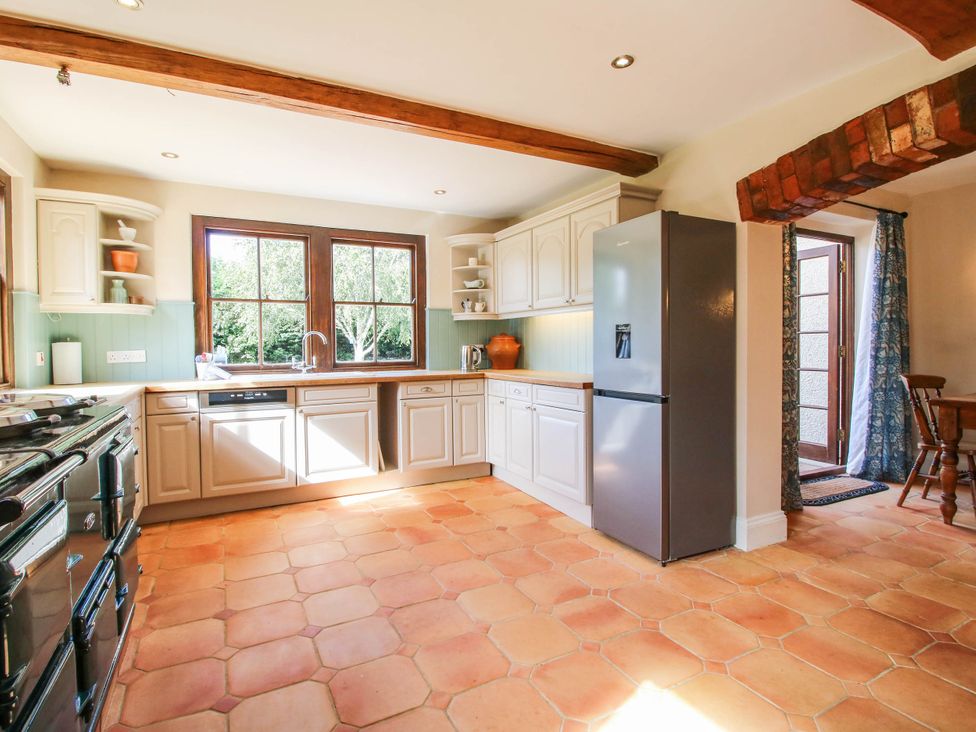 A kitchen with windows and a refrigerator at Stone House Farm in Cobnash near Leominster