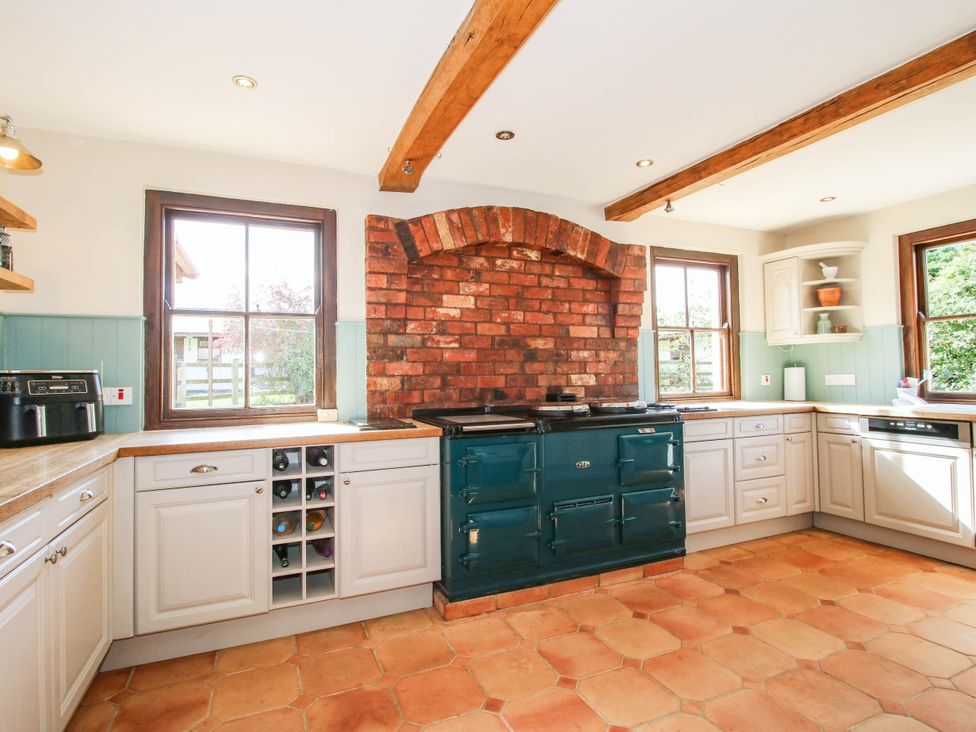 A kitchen with a stove and windows at Stone House Farm in Cobnash near Leominster