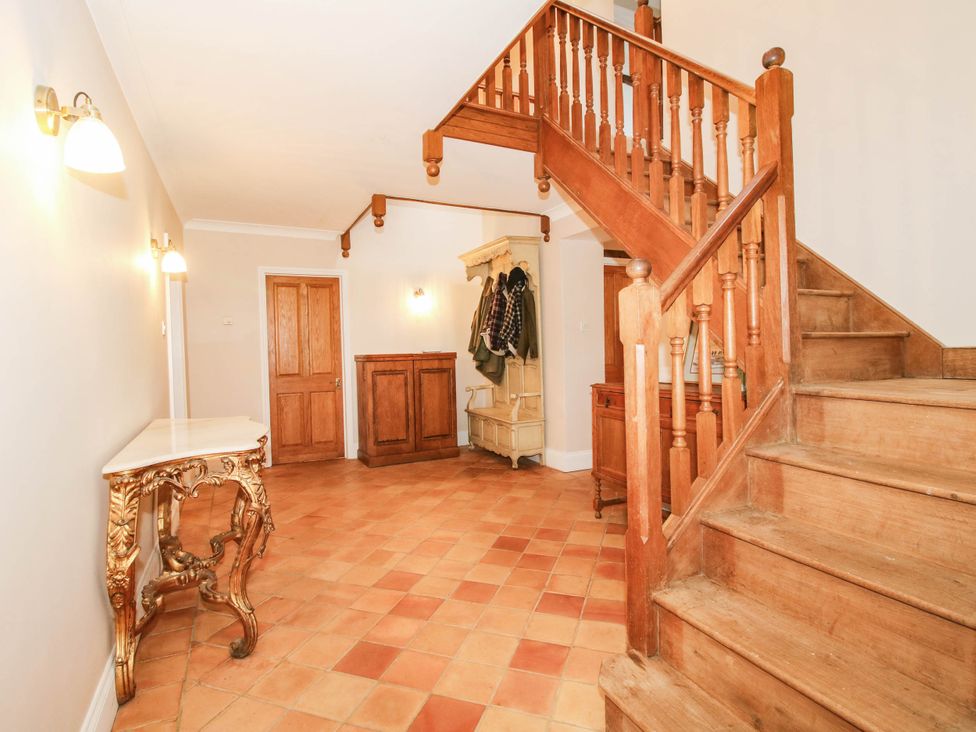 A hallway with staircase and coat rack at Stone House Farm in Cobnash near Leominster