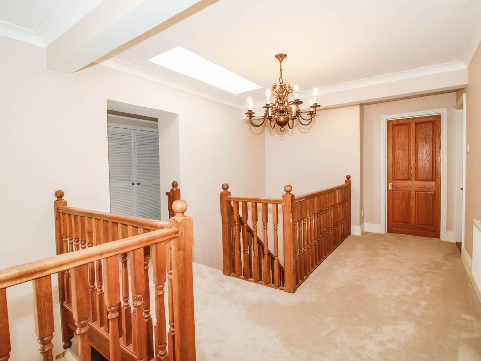 A hallway with a staircase and chandelier at Stone House Farm Cobnash near Leominster