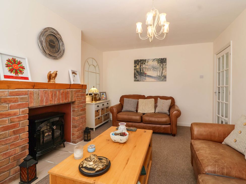 A living room with a fireplace and sofas at 56 Steart Gardens Burnham-on-Sea