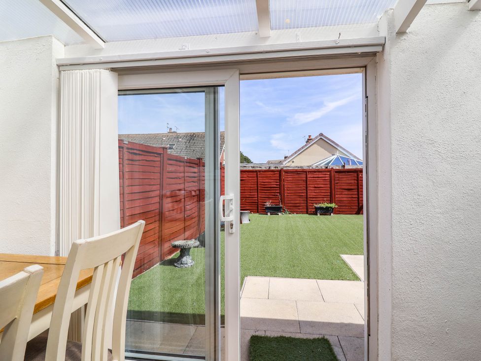 A dining room with a door leading to a garden at 56 Steart Gardens Burnham-on-Sea