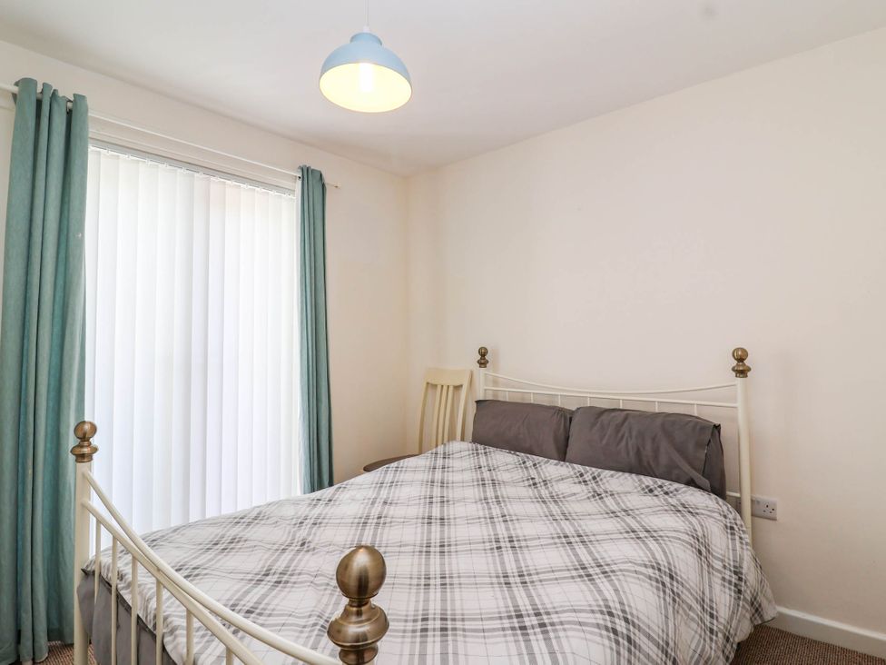 A bedroom with a bed and curtains at 56 Steart Gardens in Burnham-on-Sea