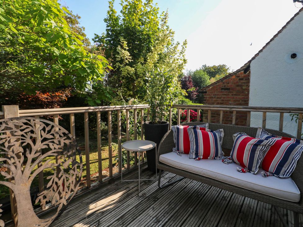 An outdoor seating area with a bench and potted plants at 41 Terminus Avenue Bexhill-On-Sea