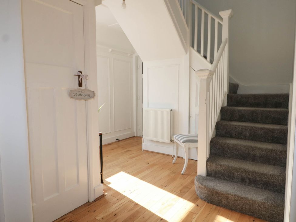 A hallway with stairs and a door at 41 Terminus Avenue in Bexhill-On-Sea