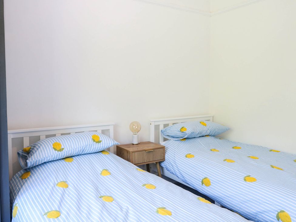 A bedroom with two beds and a lamp on a nightstand at 41 Terminus Avenue Bexhill-On-Sea