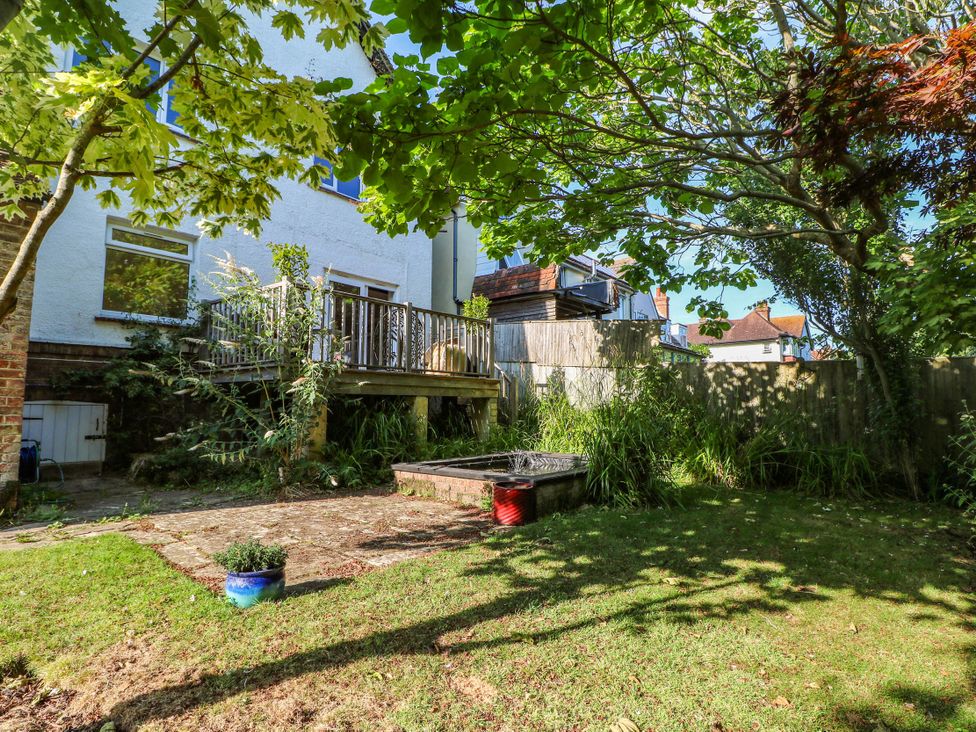 A garden with a decking area and flower pot at 41 Terminus Avenue Bexhill-On-Sea