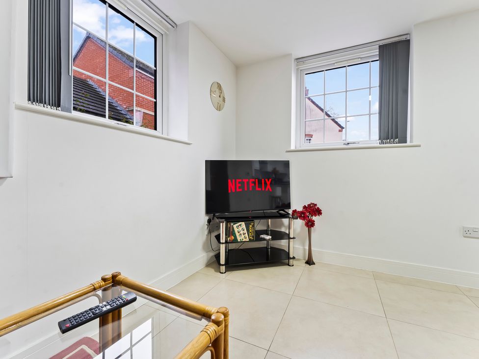 A living room with a television and a window at 2 Pump House Birmingham