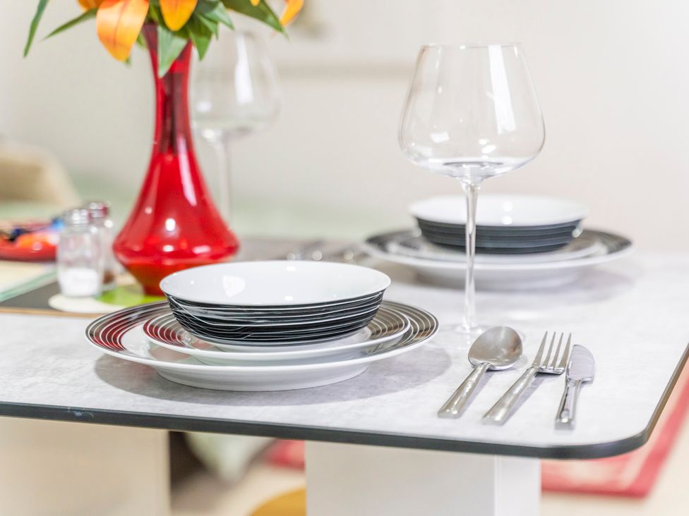 A dining table set with plates, cutlery, and a flower vase at 2 Pump House in Birmingham