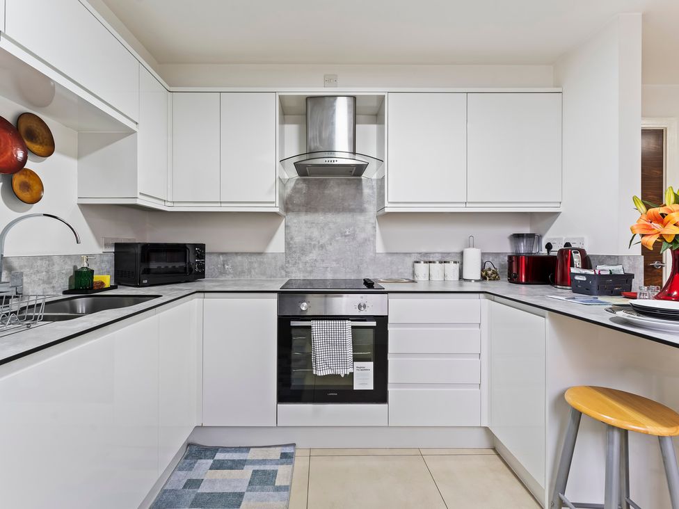 A kitchen with a stove and microwave at 2 Pump House Birmingham