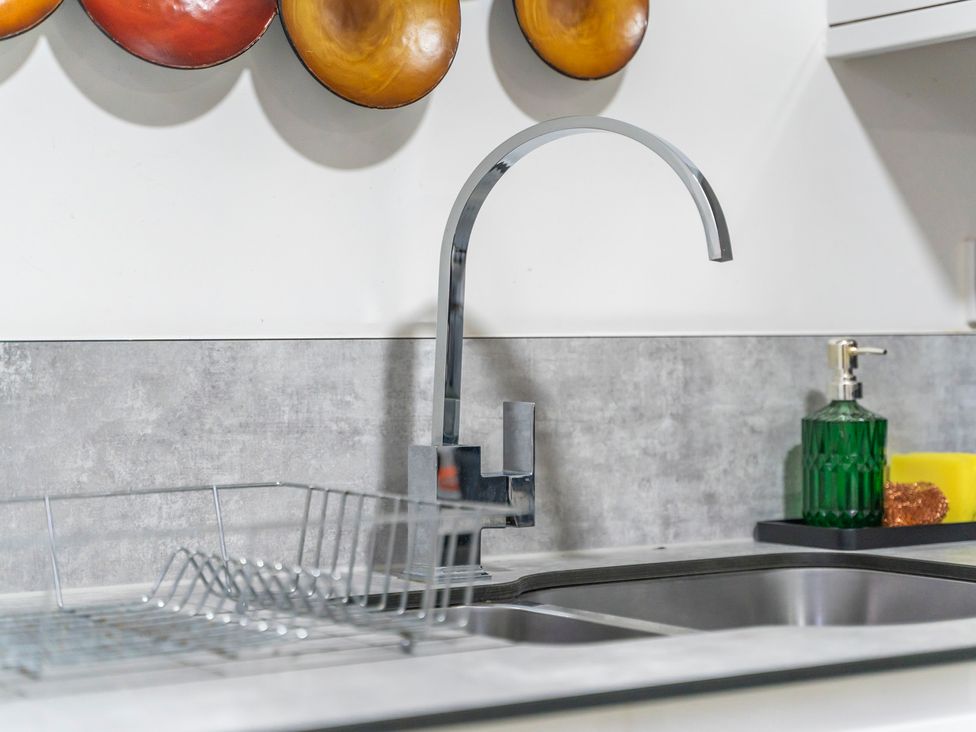 A kitchen sink with faucet and dish rack at 2 Pump House in Birmingham