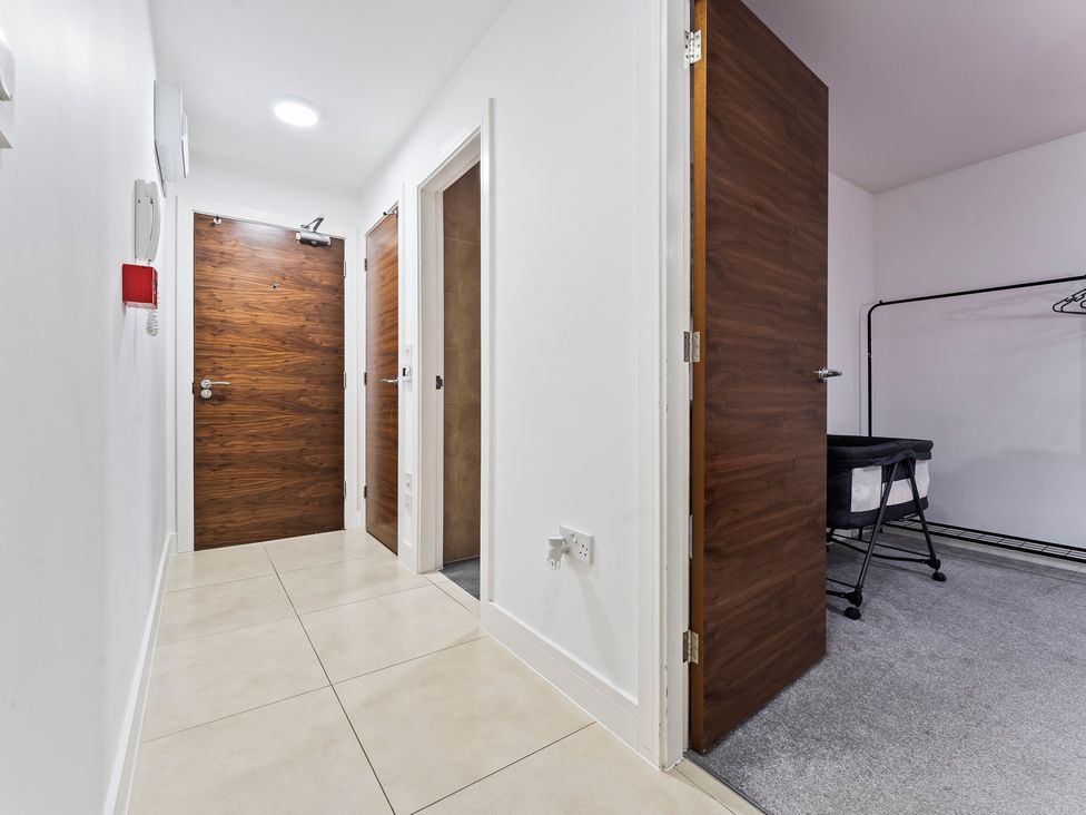 A hallway with closed doors and a wardrobe rack at 2 Pump House Birmingham
