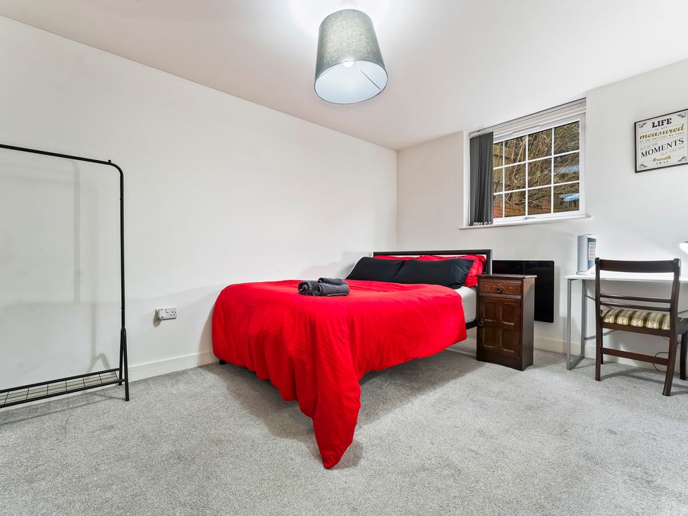 A bedroom with a bed and a chair at 2 Pump House in Birmingham