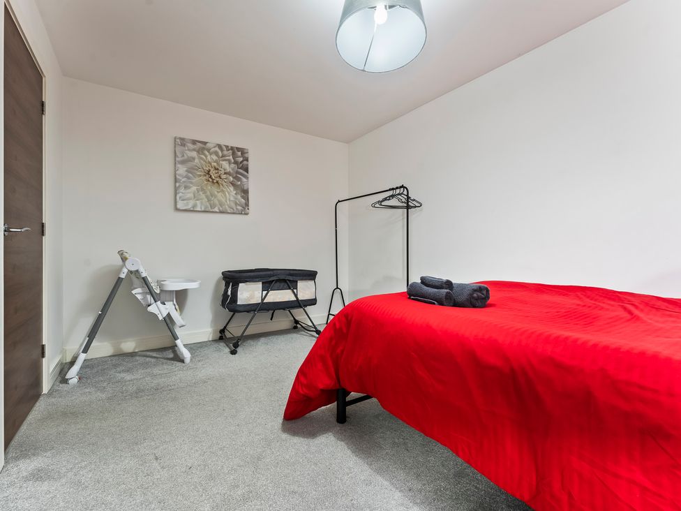 A bedroom with a bed and clothing rack at 2 Pump House in Birmingham
