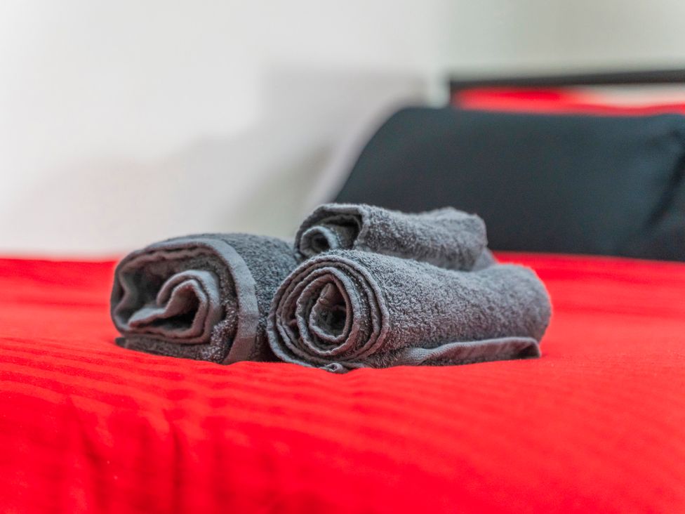 Towels on a red bed at 2 Pump House in Birmingham