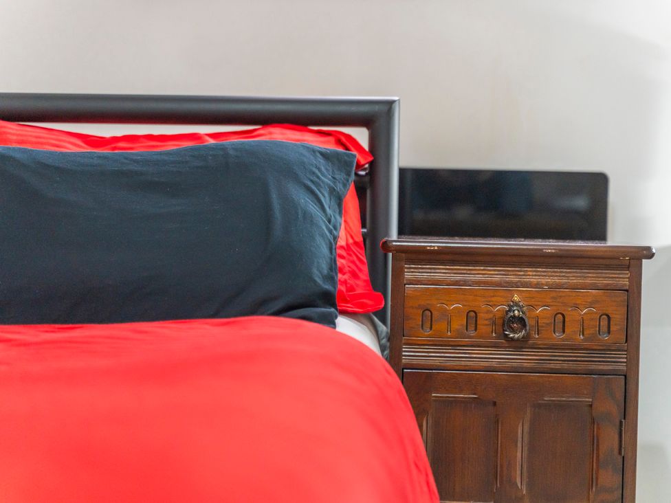 A bedroom with a bed and nightstand at 2 Pump House in Birmingham