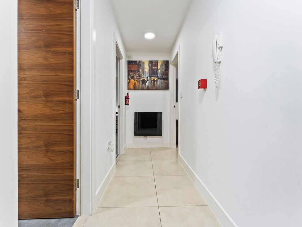 A hallway with a door and wall art at 2 Pump House Birmingham