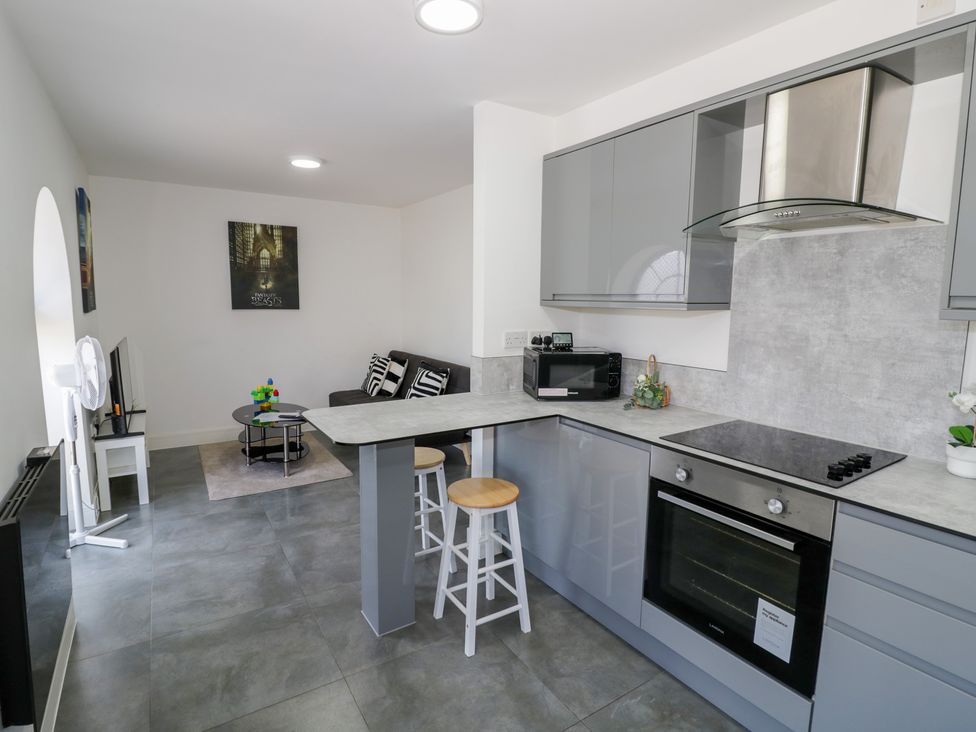 A kitchen with a table and stools at 3 Pump House in Birmingham