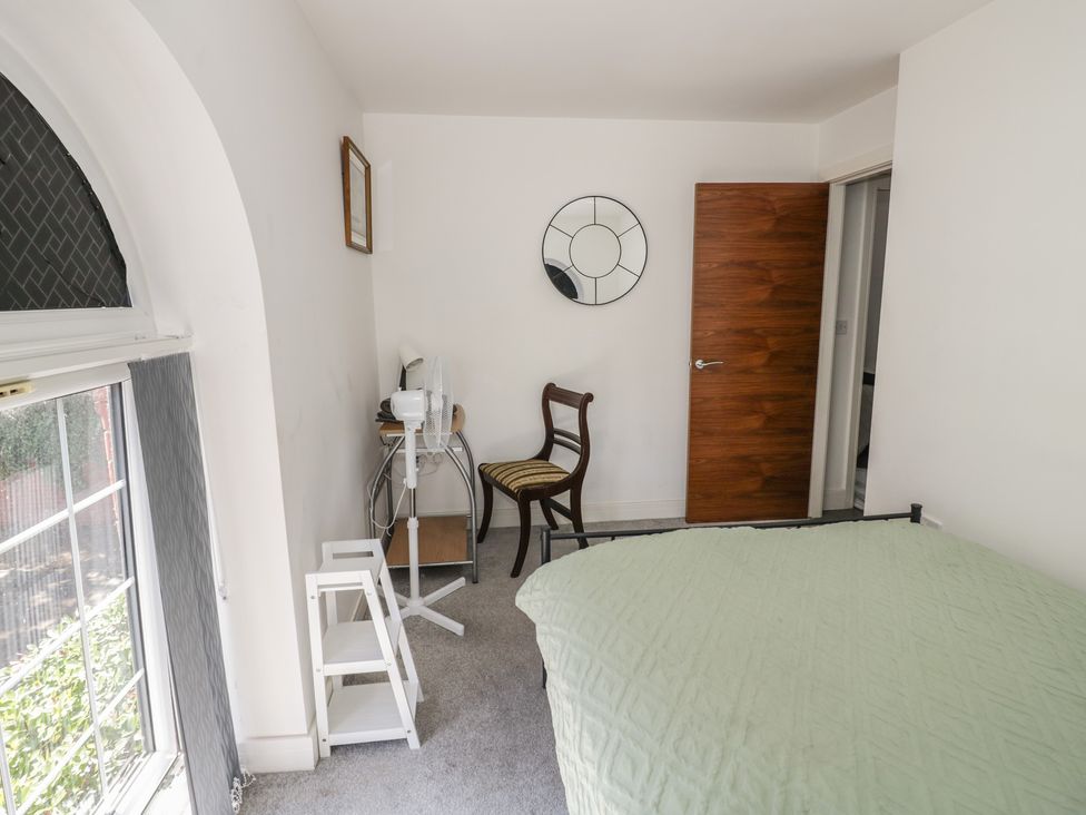 A bedroom with a bed, chair, mirror and table at 3 Pump House in Birmingham