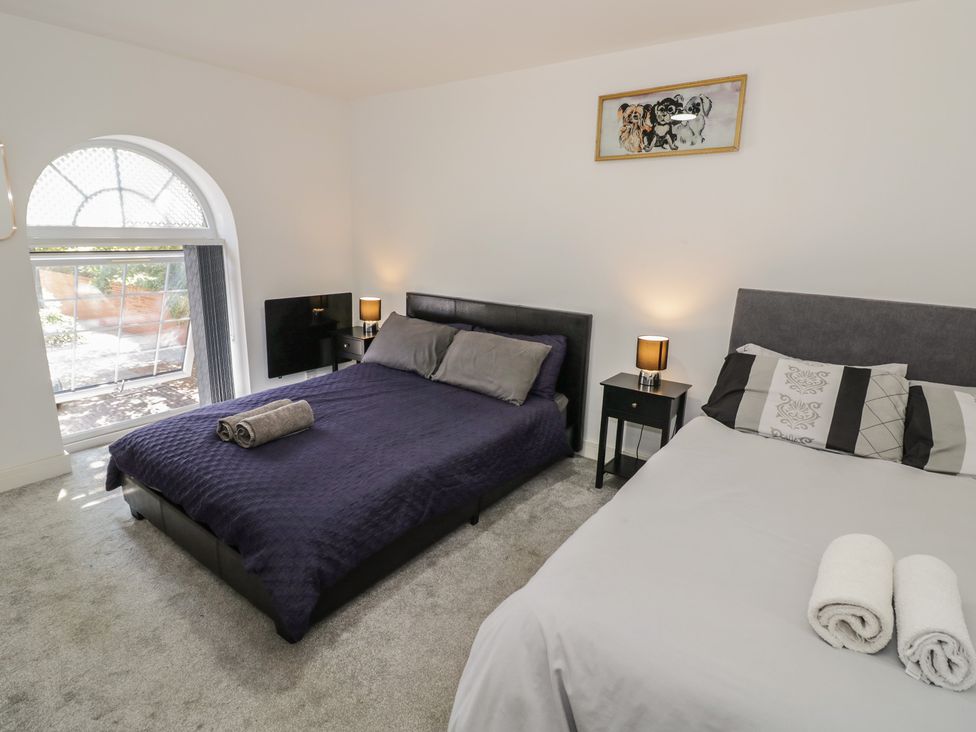A bedroom with two beds and a television at 3 Pump House in Birmingham