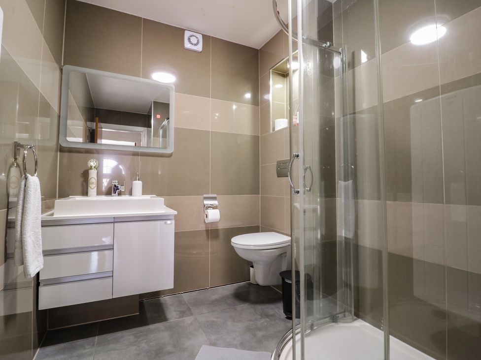 A bathroom with a shower, toilet, and sink at 3 Pump House in Birmingham