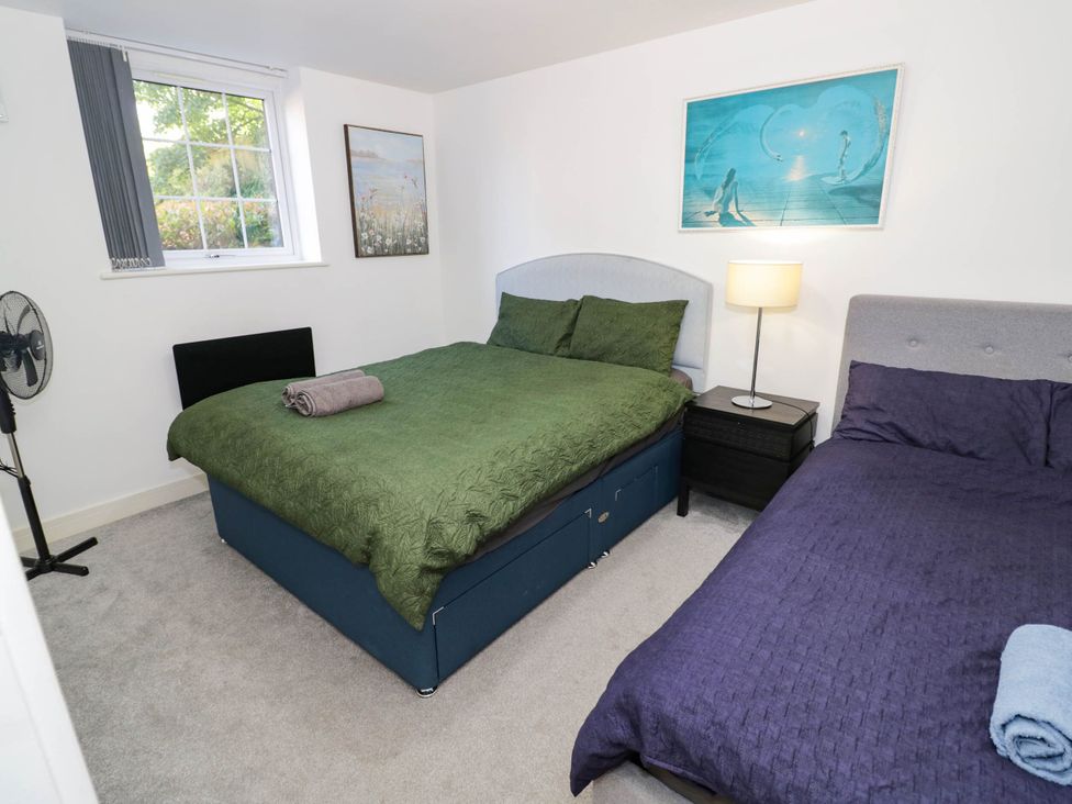 A bedroom with two beds and a nightstand at 4 Pump House Birmingham