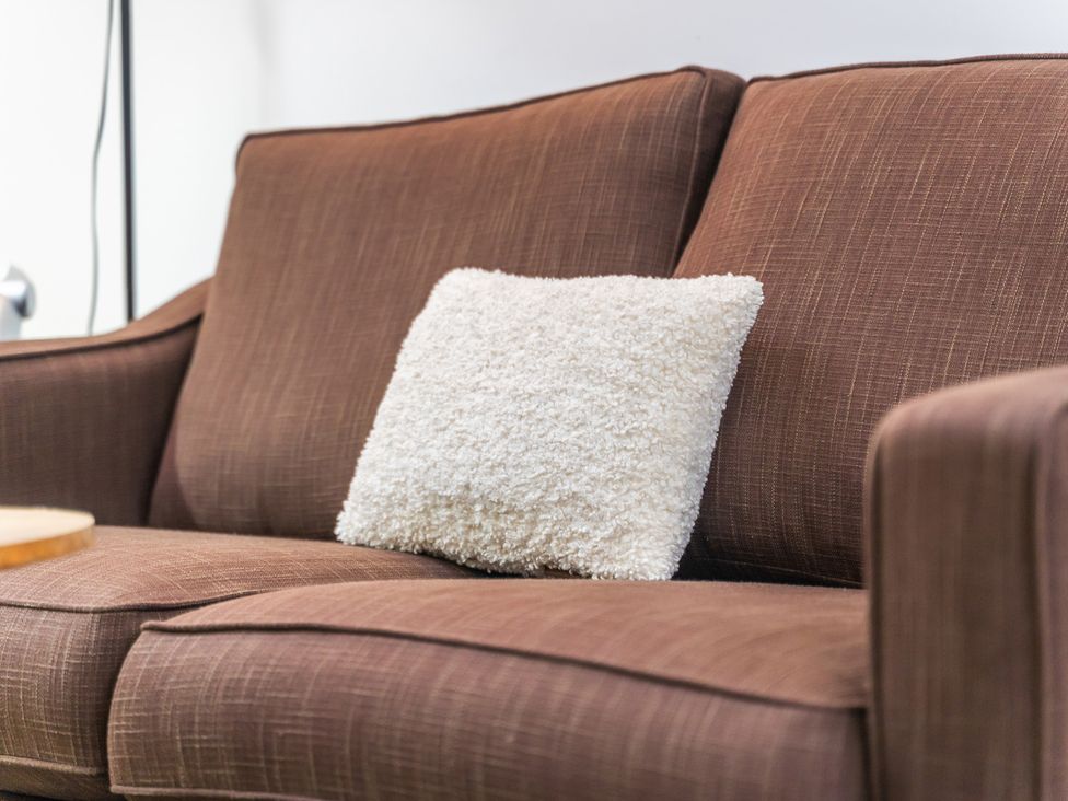 A sofa with a white pillow at 5 Pump House Birmingham