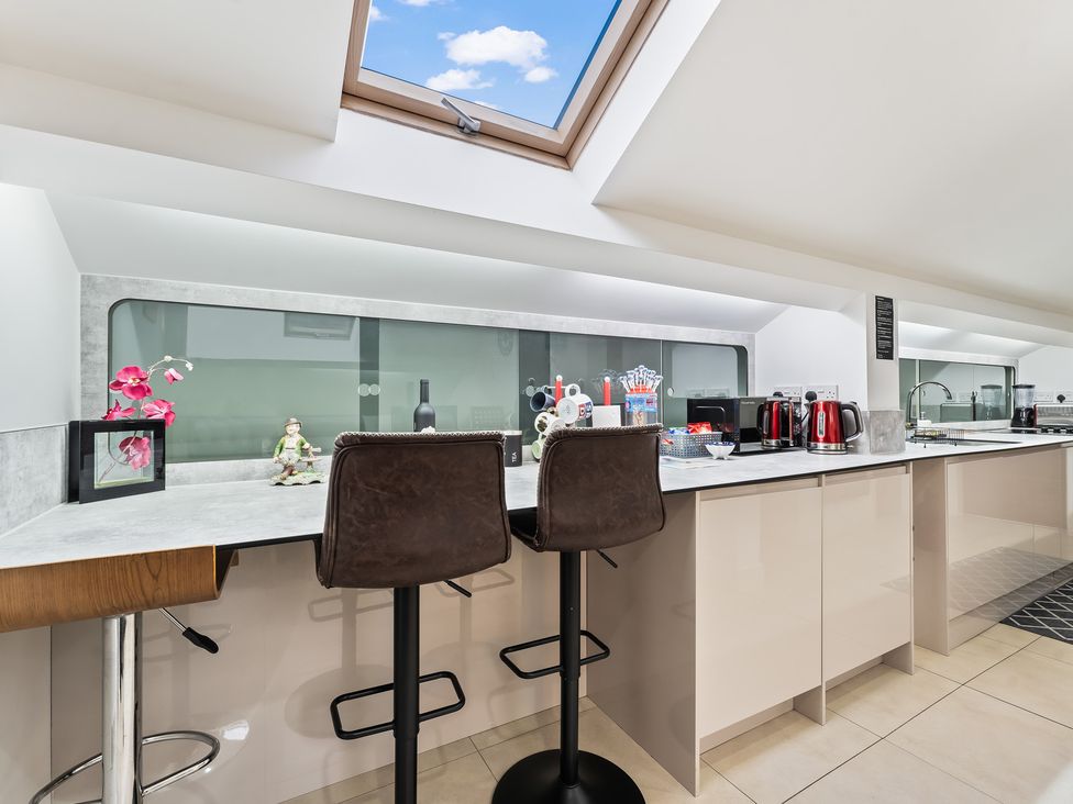 A kitchen with bar stools and a skylight at 5 Pump House in Birmingham