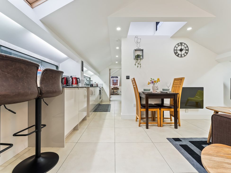 A kitchen with bar stools and a dining table at 5 Pump House in Birmingham