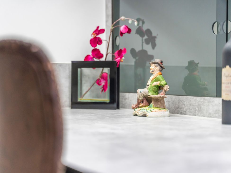 A table with a ceramic statue, flower arrangement and picture frame at 5 Pump House in Birmingham